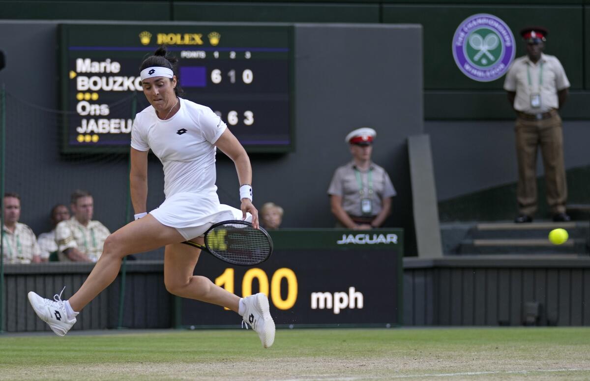 Tunisia's Ons Jabeur returns from between her legs to Marie Bouzkova of the Czech Republic in a women's singles quarterfinal match on day nine of the Wimbledon tennis championships in London, Tuesday, July 5, 2022. (AP Photo/Alastair Grant)