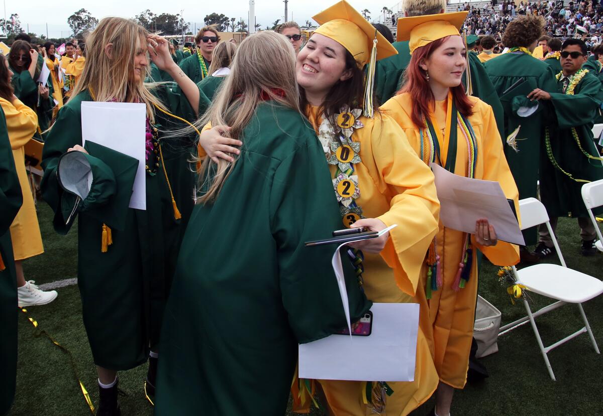 Jubilant Edison graduates hug one another at the end of Wednesday's commencement ceremony.