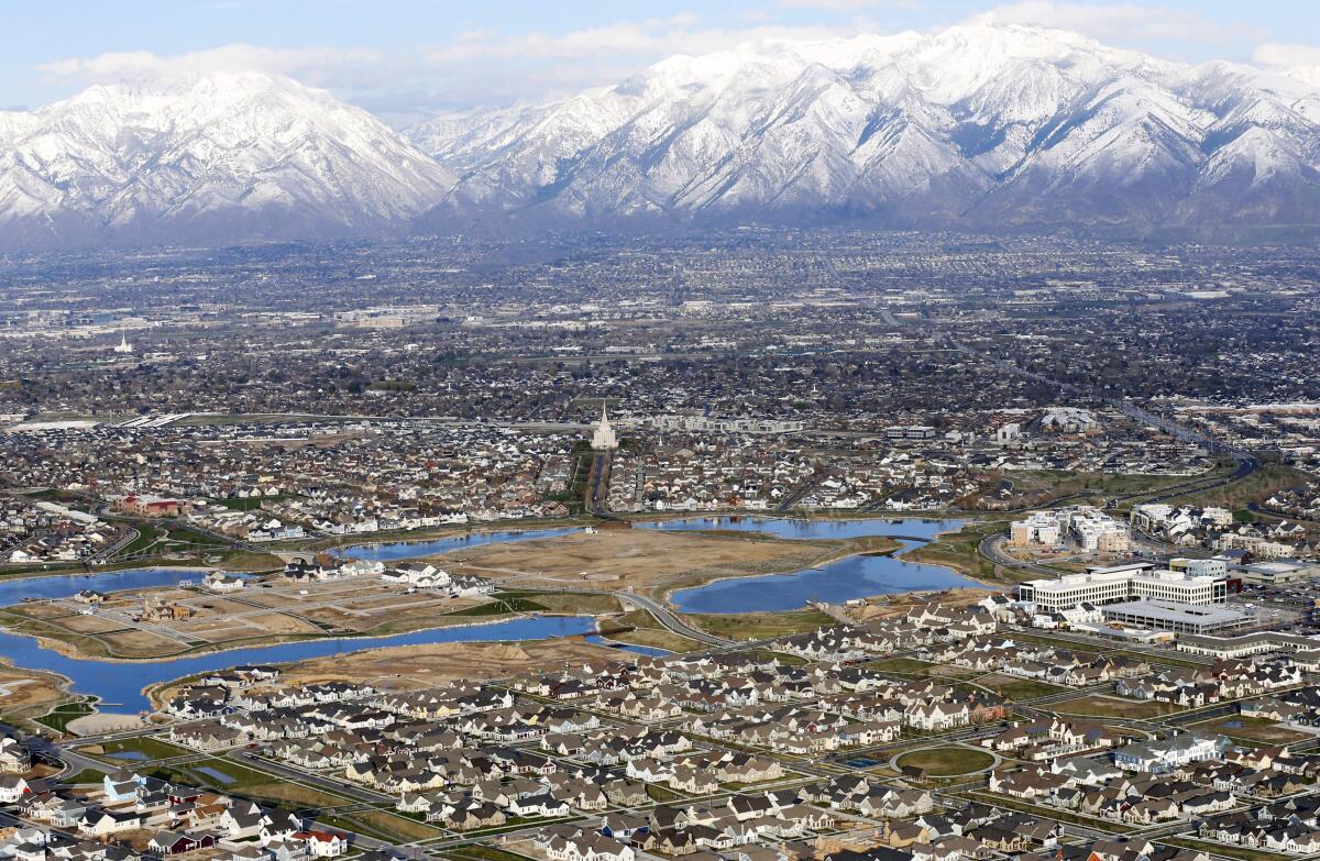 An overview of homes in suburban Salt Lake City with snowcapped mountains in the background