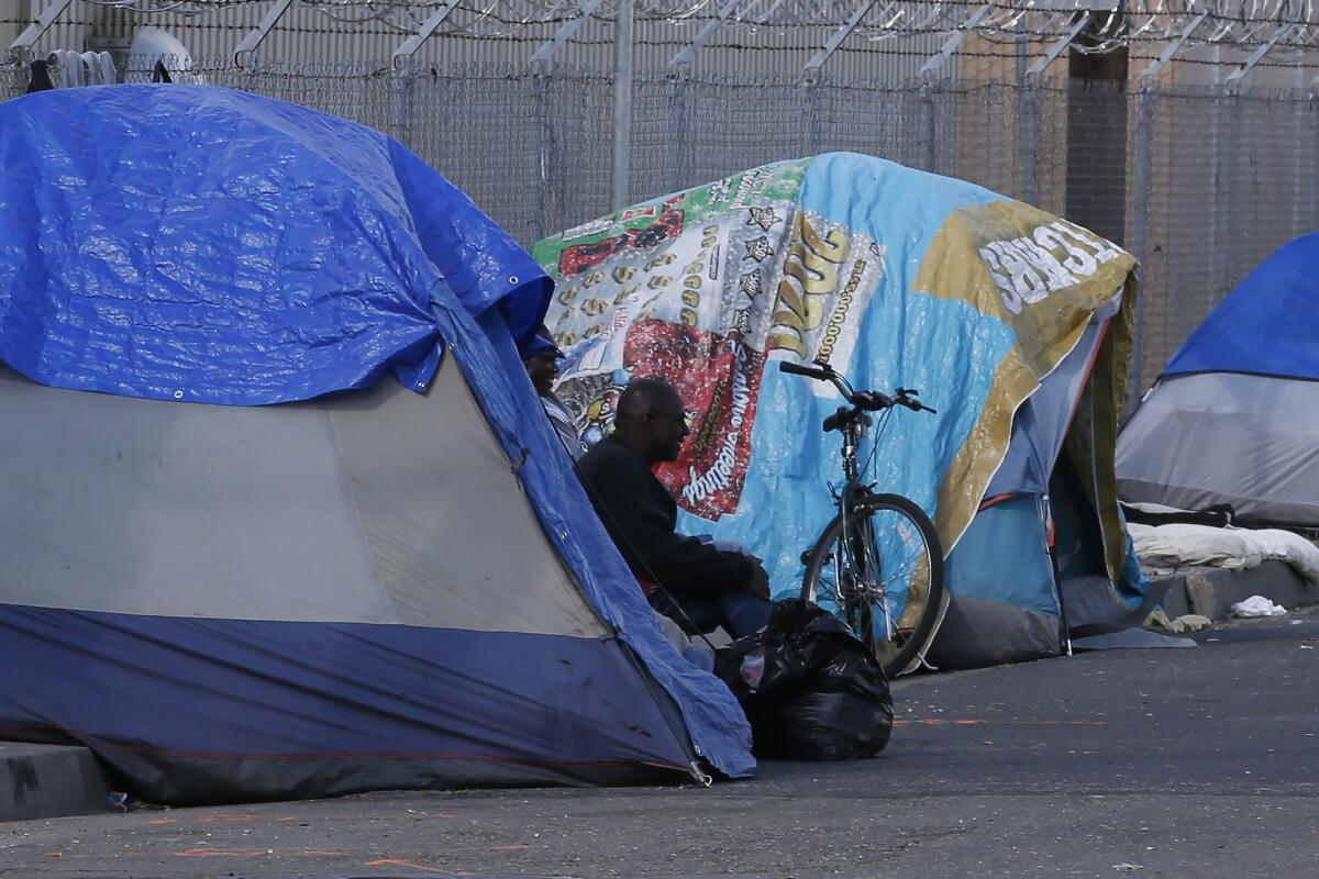 A homeless man sits in a tent in Sacramento in 2020. 