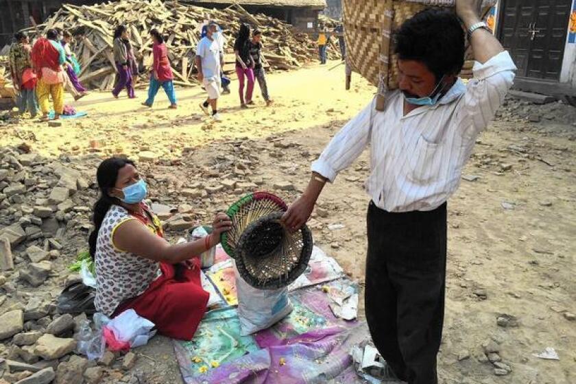 Ratna Bahadur Malatar and his wife, Mithai, work on assembling flower garlands in Katmandu's Durbar Square.