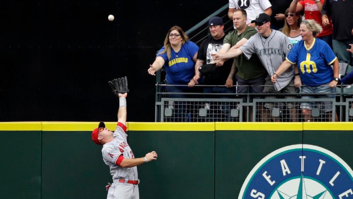 Angels outfielder Mike Trout goes up to rob the Mariners' Leonys Martin of a grand slam during a game in Seattle on Aug. 7, Trout's 25th birthday.
