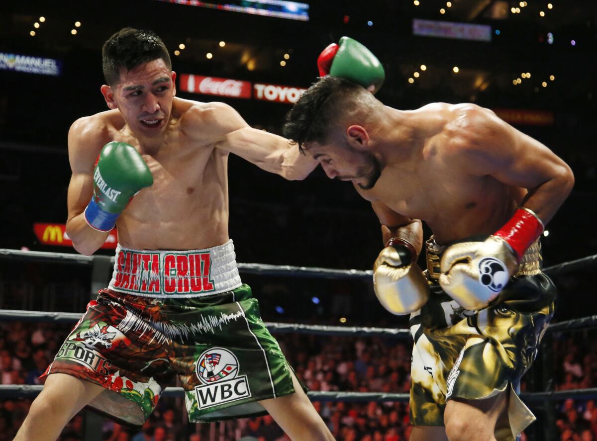 Leo Santa Cruz, left, exchanges punches with Abner Mares during their WBC diamond featherweight and WBA featherweight championship boxing bout, Saturday, Aug. 29, 2015, in Los Angeles.