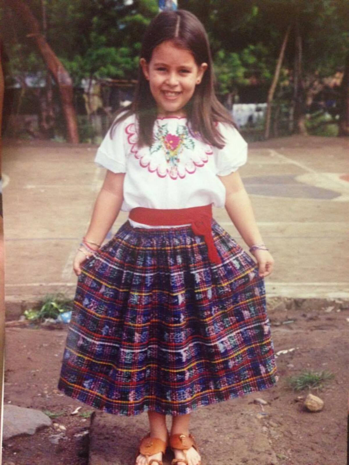 Arteaga as a little girl wearing traditional Guatemalan cultural clothing.