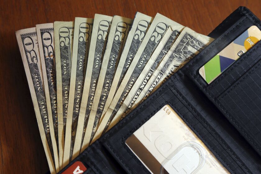 FILE - In this June 15, 2018, file photo, cash is fanned out from a wallet in North Andover, Mass. With lives and finances strained by the novel coronavirus pandemic, now is the time to focus on your money management skills. (AP Photo/Elise Amendola, File)