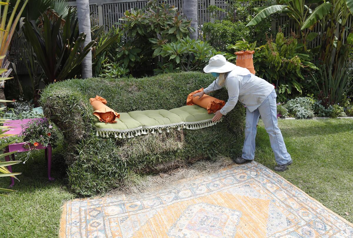 Sherman Gardens Senior Horticulturist Carol Younger touches-up the "parlor" couch in the greenHOUSE exhibit Wednesday.