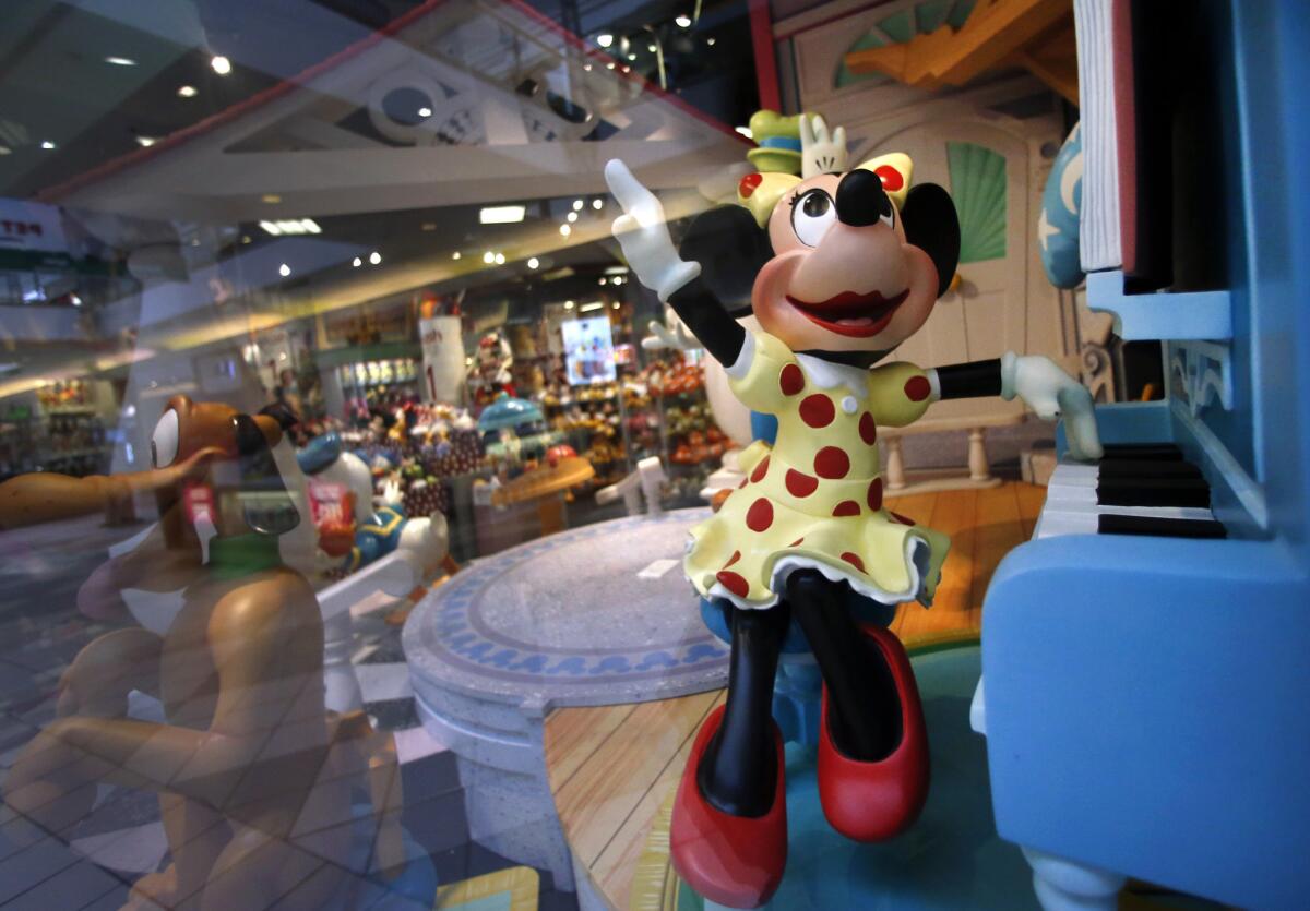 Minnie Mouse plays piano in a Disney Store display window in this file photo.