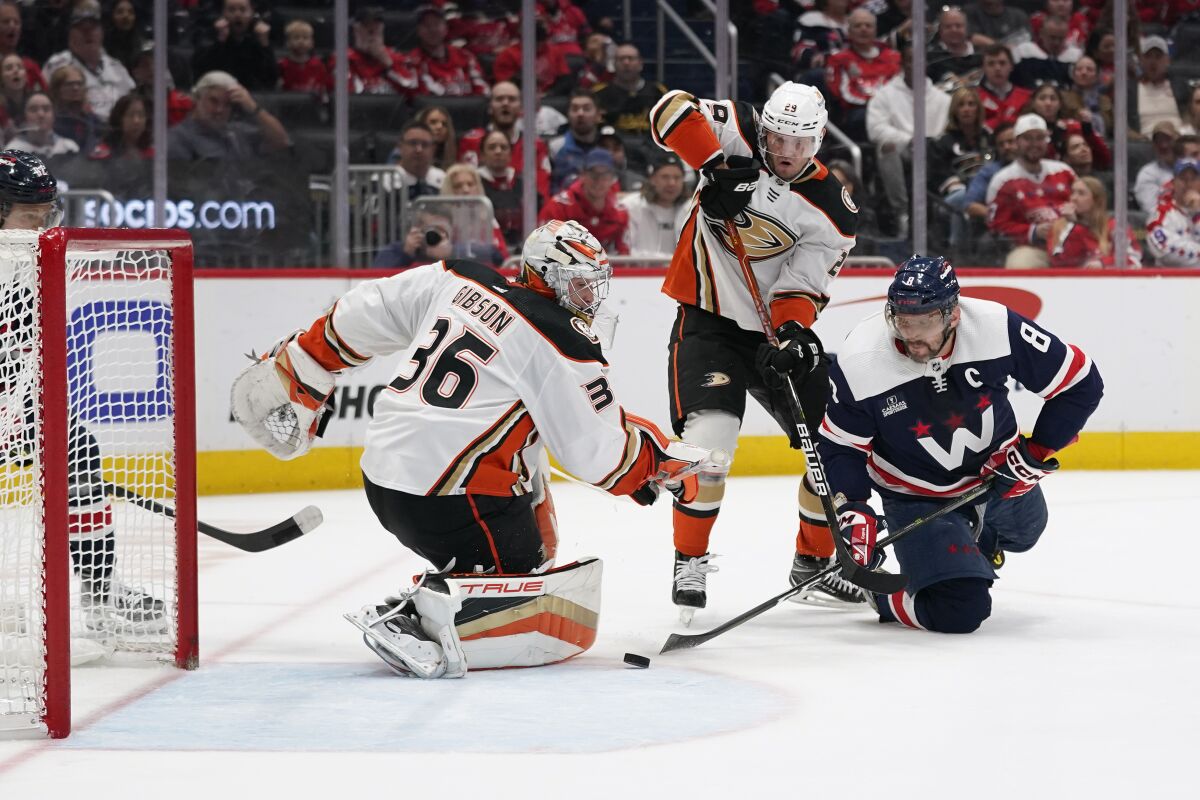 Washington Capitals' Alex Ovechkin attempts a shot but is unable to score a goal past Ducks' John Gibson and Dmitry Kulikov.