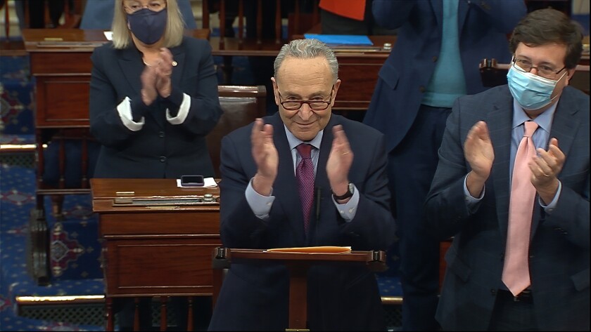 In this image from video, Senate Majority Leader Chuck Schumer of N.Y., leads a round of applause for support staff as he speaks before the final vote on the Senate version of the COVID-19 relief bill in the Senate at the U.S. Capitol in Washington, Saturday, March 6, 2021. (Senate Television via AP)