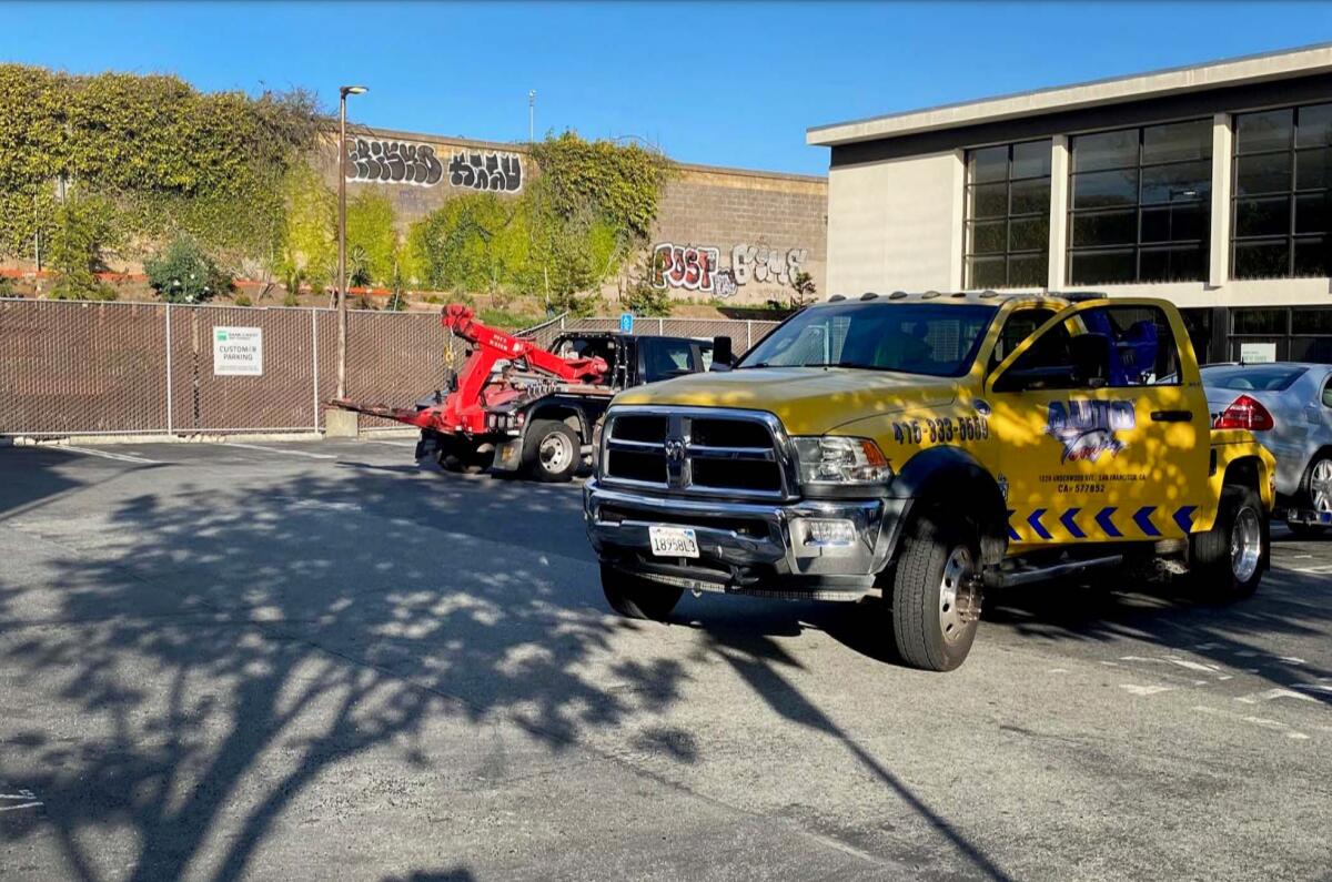 Tow trucks parked next to a building.