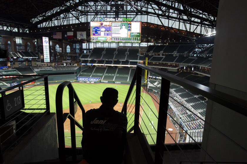 Globe Life Park custodian Erazmo Gonzalez watches from the upper deck during an opening day baseball game between the Texas Rangers and the Colorado Rockies, Friday, July 24, 2020, in Arlington, Texas. (AP Photo/Jeffrey McWhorter)