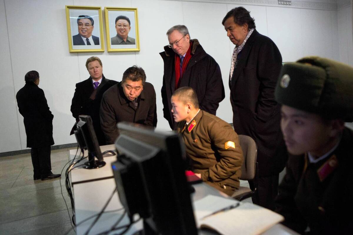 Google Executive Chairman Eric Schmidt, red scarf, and former New Mexico Gov. Bill Richardson, standing, right, watch North Korean soldiers working on computers at the Grand Peoples Study House in Pyongyang. The two are on what they described as a private humanitarian visit.