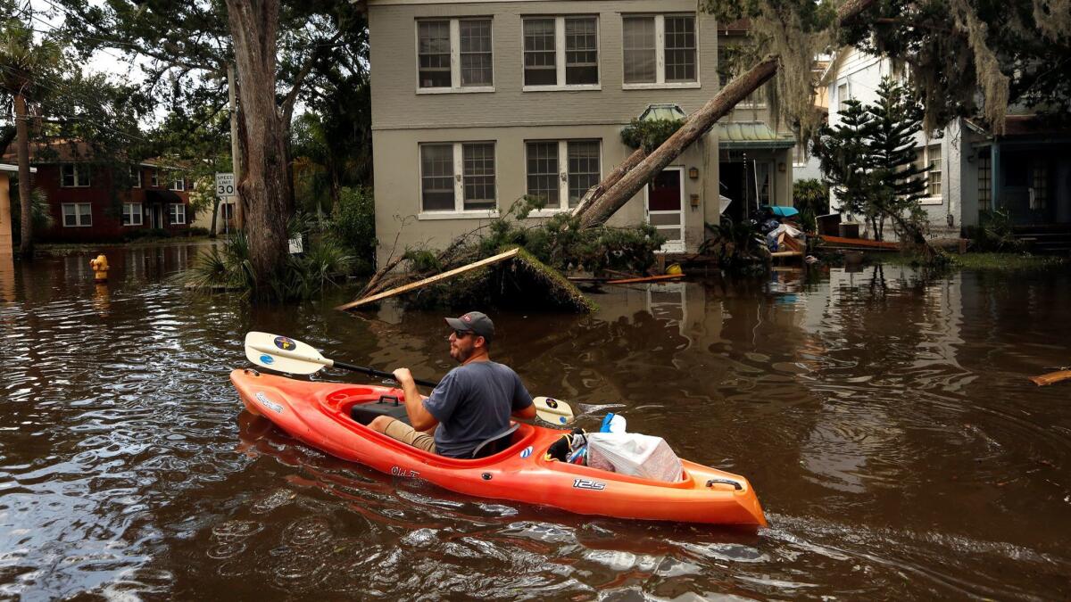 In the San Marco area of Jacksonville, Fla., on Sept. 12, 2017, Joshua Young takes some of his personal belonging out by kayak after flooding hit his apartment building following Hurricane Irma.