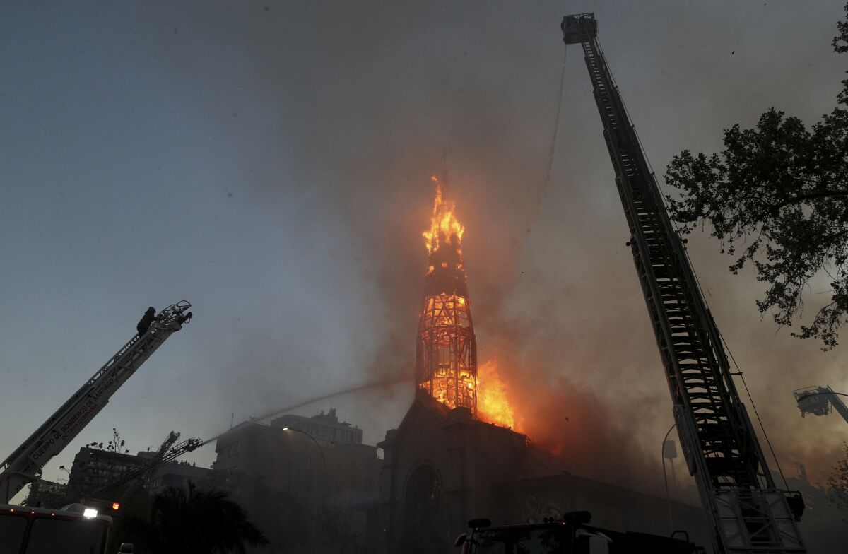 Firefighters battle flames at La Asunción Church after it was attacked.