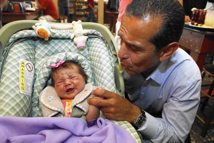 Antonio Villaraigosa greets a baby at Philippe the Original restaurant in Los Angeles in June 2013. The former L.A. mayor is considering running for the U.S. Senate seat being vacated by Barbara Boxer.