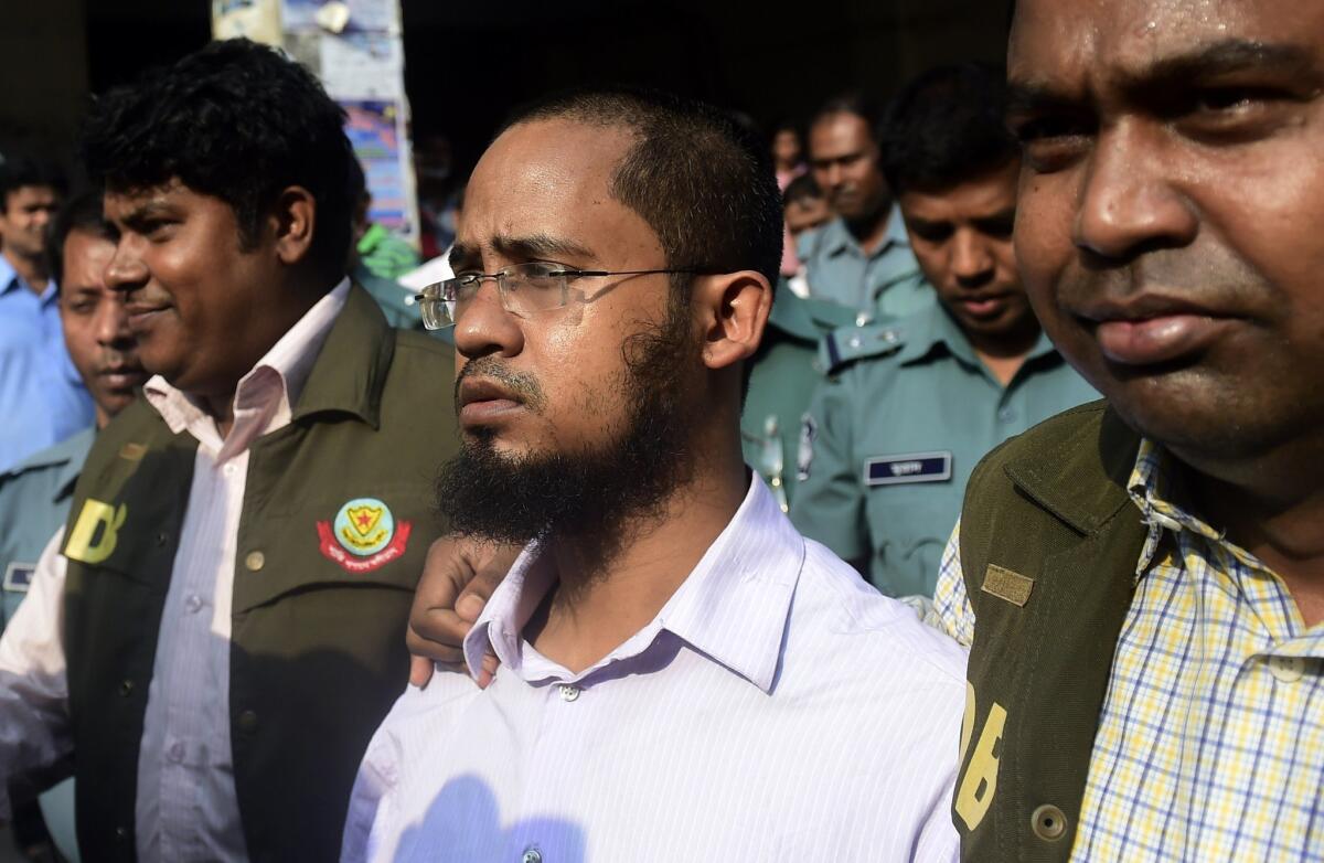 Bangladesh police escort Farabi Shafiur Rahman, center, as he appears in court March 3 following his arrest in connection with the slaying of an atheist American blogger in Dhaka.