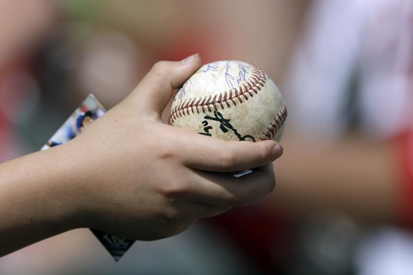 A young fan holds a baseball in hopes of getting an autograph before a spring training baseball game between the Minnesota Twins and the Boston Red Sox Monday, Feb. 24, 2020, in Fort Myers, Fla. (AP Photo/John Bazemore)