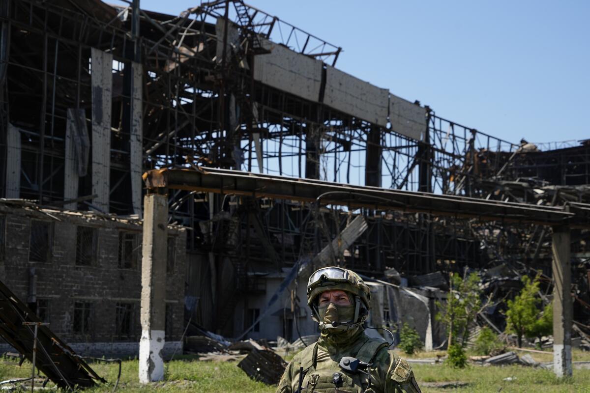 Russian soldier walking through heavily damaged factory complex