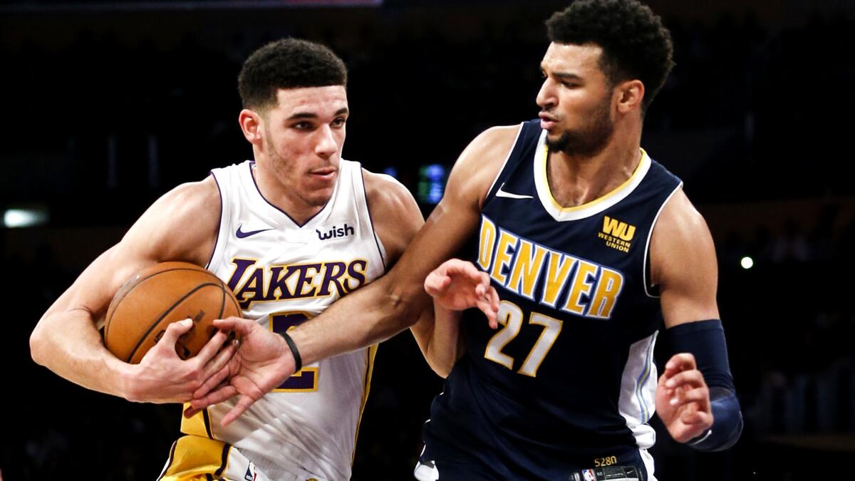 Lakers guard Lonzo Ball tries to drive past Nuggets guard Jamal Murray during the first half Sunday.