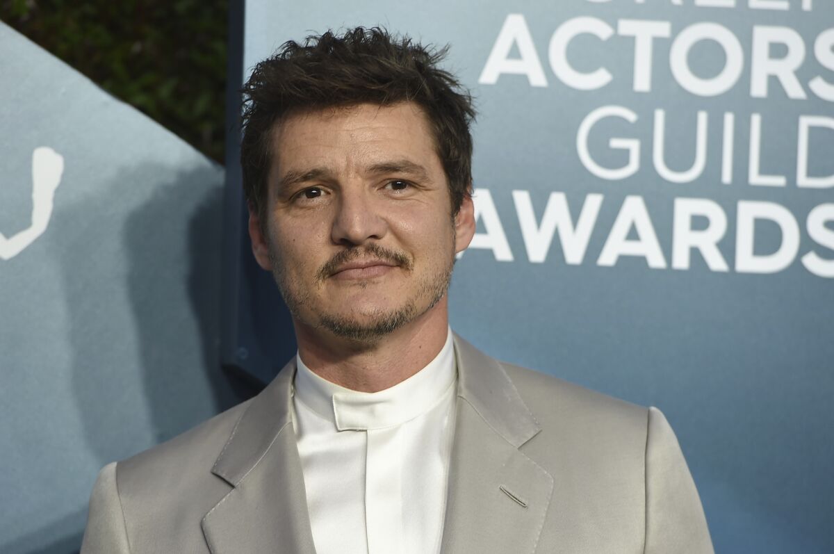 Pedro Pascal posing in a silver suit