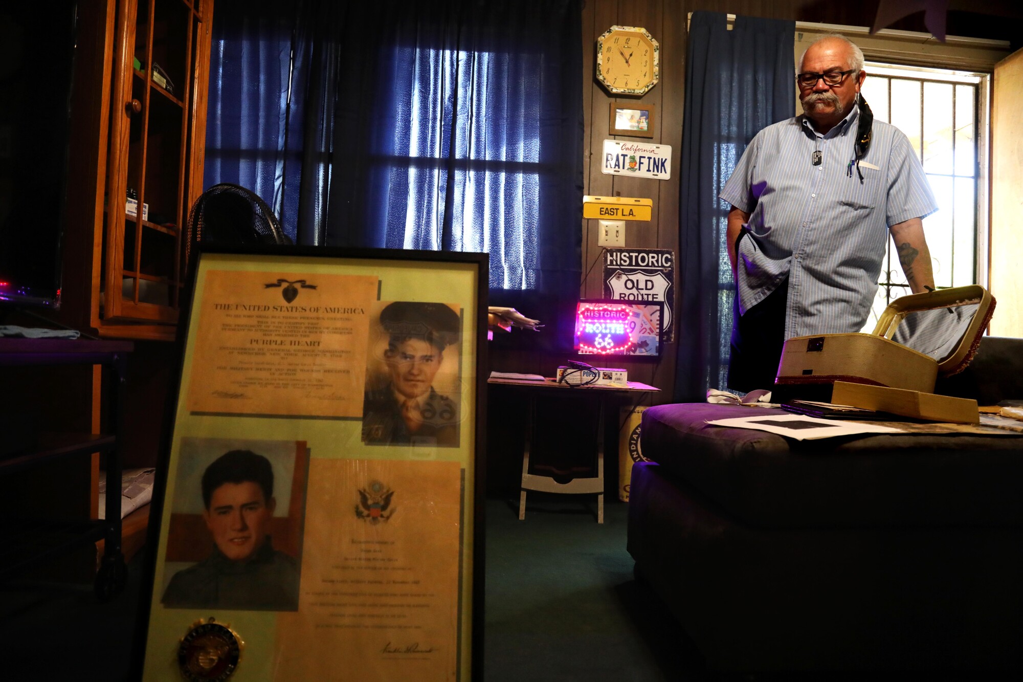 Isaac Cruz III looks toward a picture frame that holds photos and certificates for Jacob Cruz.