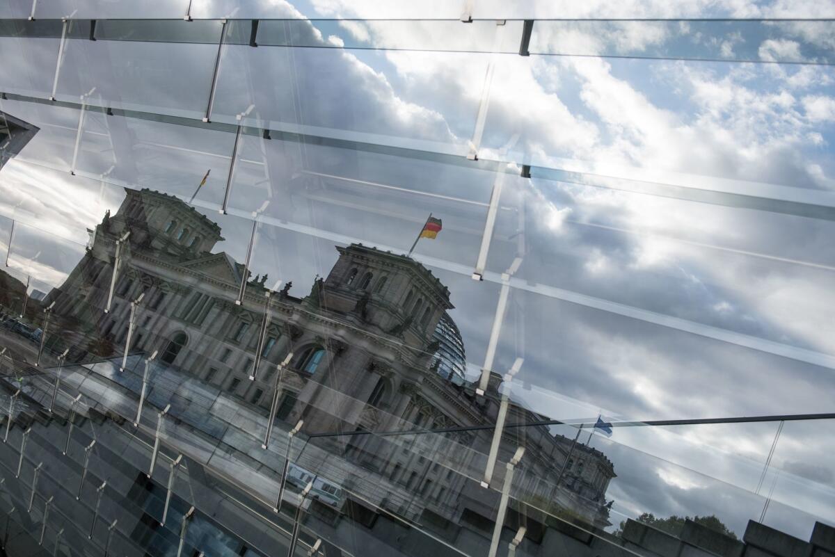The Reichstag building, which houses the Bundestag lower house of Parliament in Berlin, is shown in a reflection. Hundreds of German politicians were targeted in the cyberattacks.