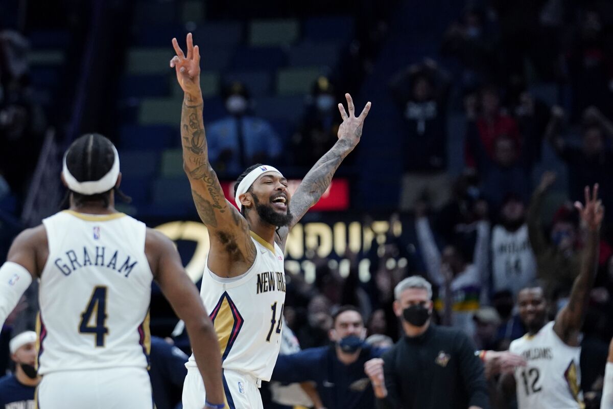 New Orleans Pelicans forward Brandon Ingram (14) celebrates his buzzer-beating 3-point shot to defeat the Minnesota Timberwolves in the second half of an NBA basketball game in New Orleans, Tuesday, Jan. 11, 2022. The Pelicans won 128-125. (AP Photo/Gerald Herbert)