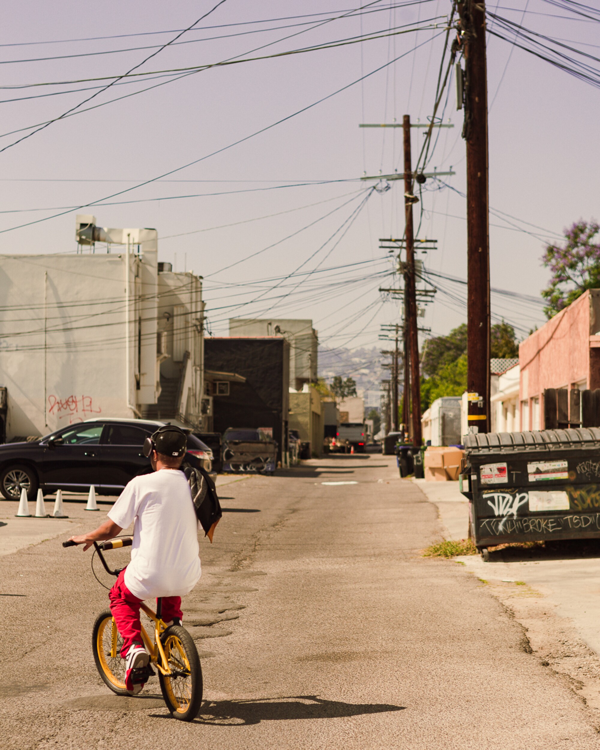 A person rides a bike in an alley.