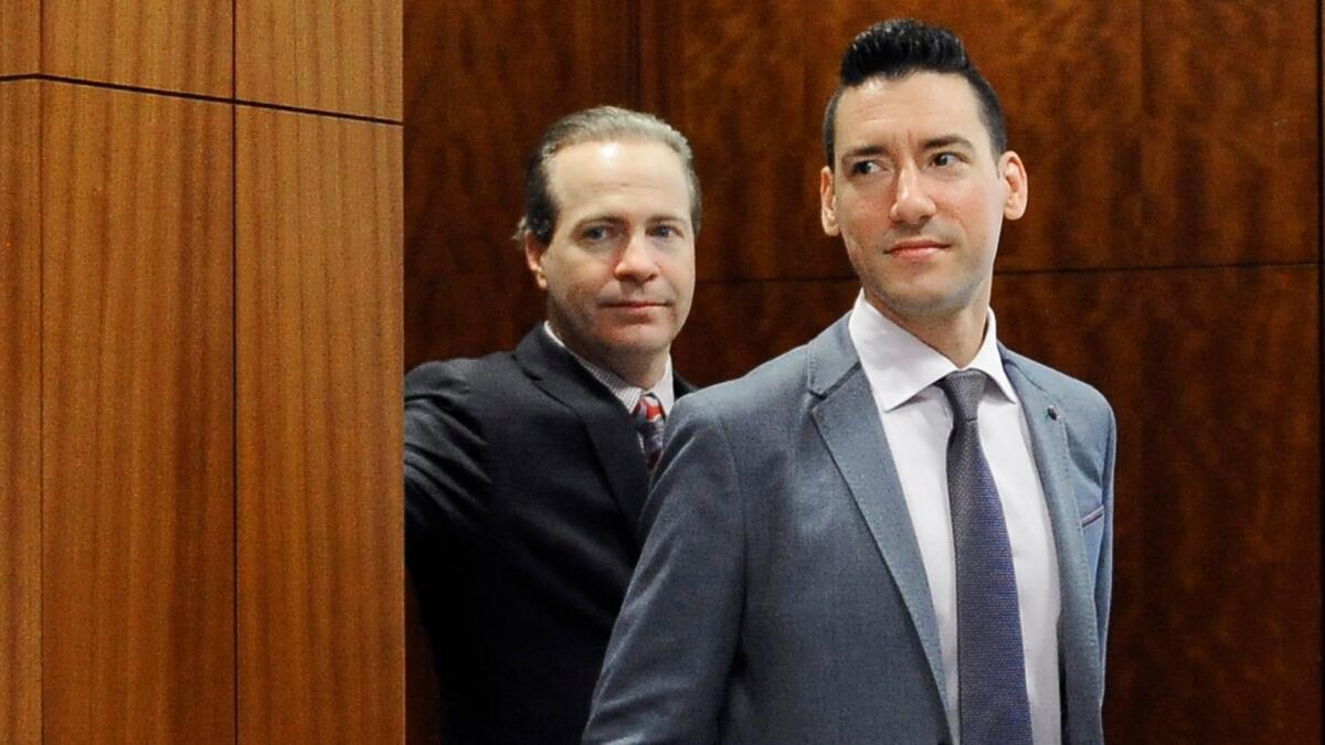David Robert Daleiden, right, one of two anti-abortion activists charged in California with 15 felony counts, is seen leaving a courtroom in Houston.