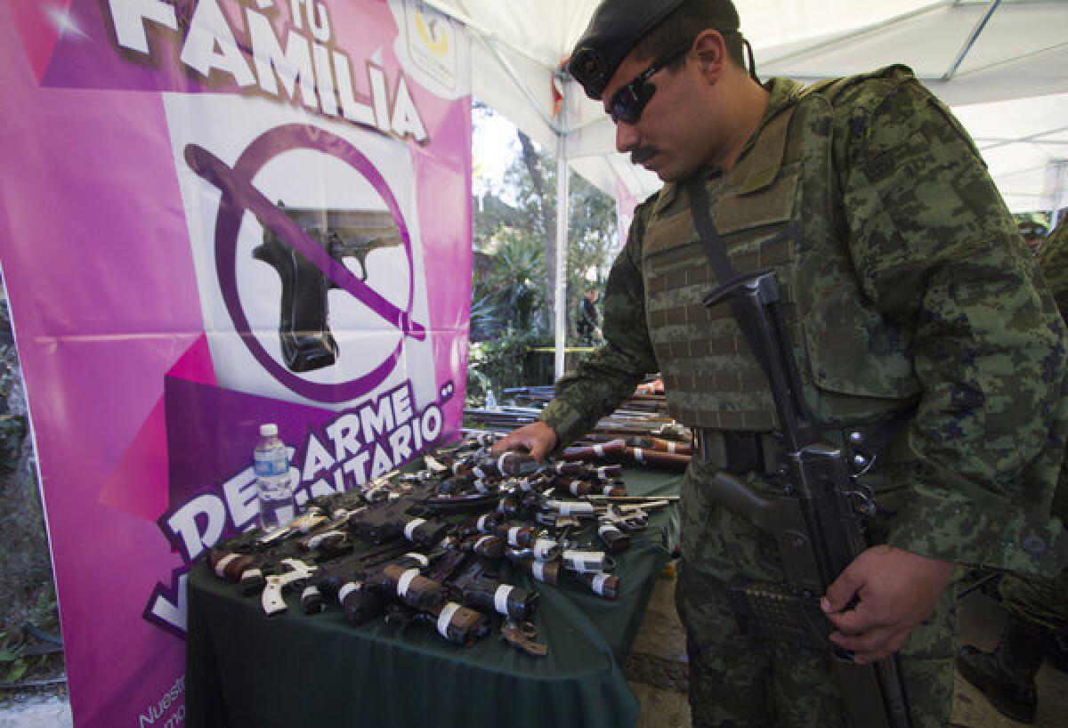 A member of the Mexican Army checks guns handed in as part of a an exchange program launched by government officials in the Iztapalapa borough of Mexico City.