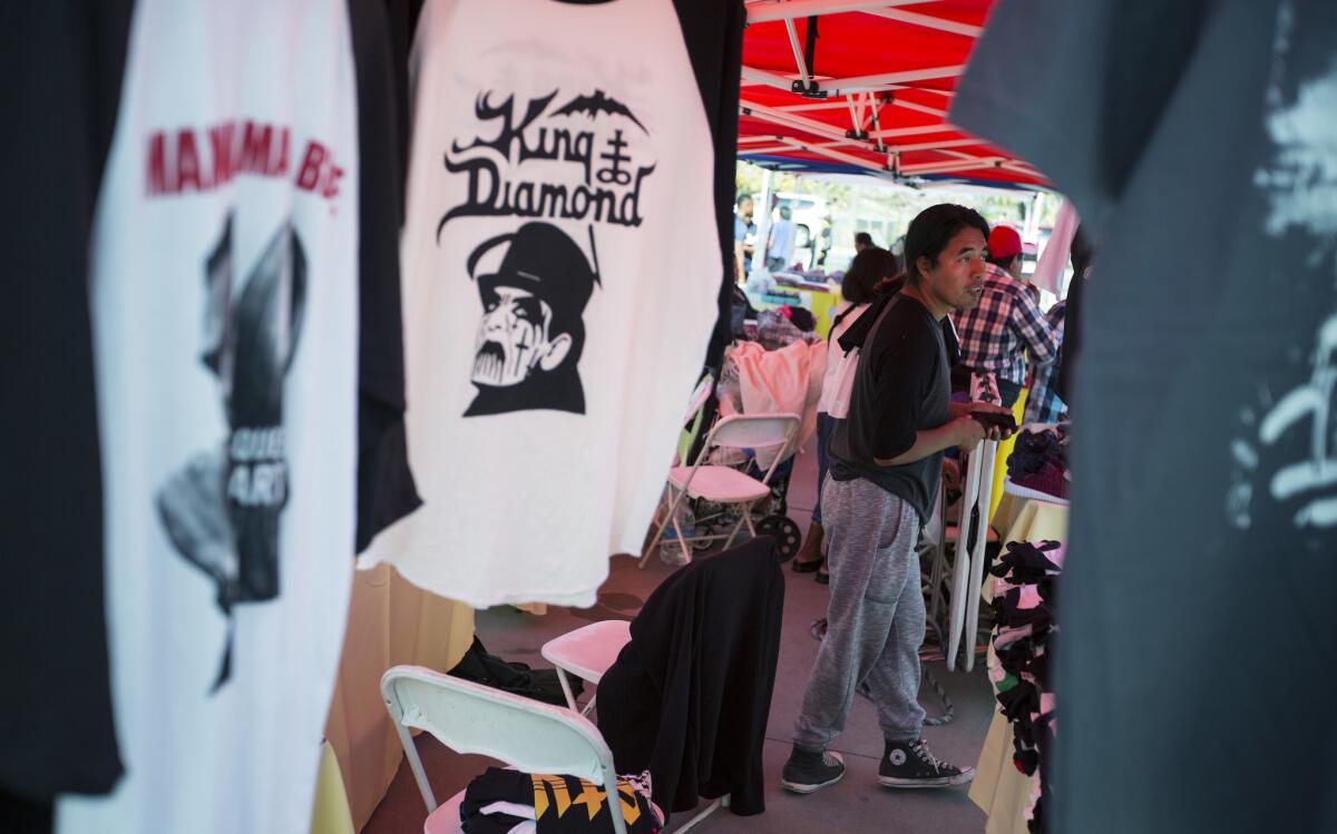 Street vendor Rufino Tzunun waits for customers at his T-shirt booth at the Westlake/MacArthur Park Metro Line station.