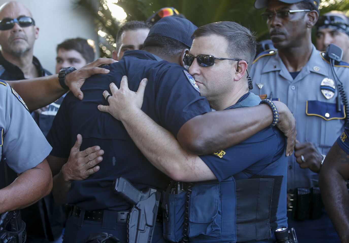 Baton Rouge Police Officers hug each other during a rally with nearly 400 motorcycle riders from various local clubs who rode to police headquarters to show thier support.