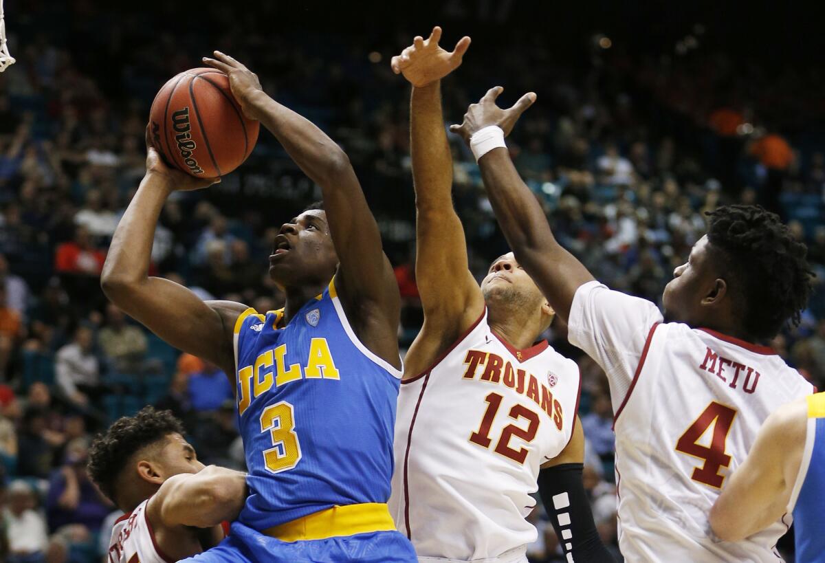 UCLA guard Aaron Holiday (3) shoots next to USC guard Julian Jacobs (12) and forward Chimezie Metu (4) during the second half of a Pac-12 Conference tournament game on March 9.