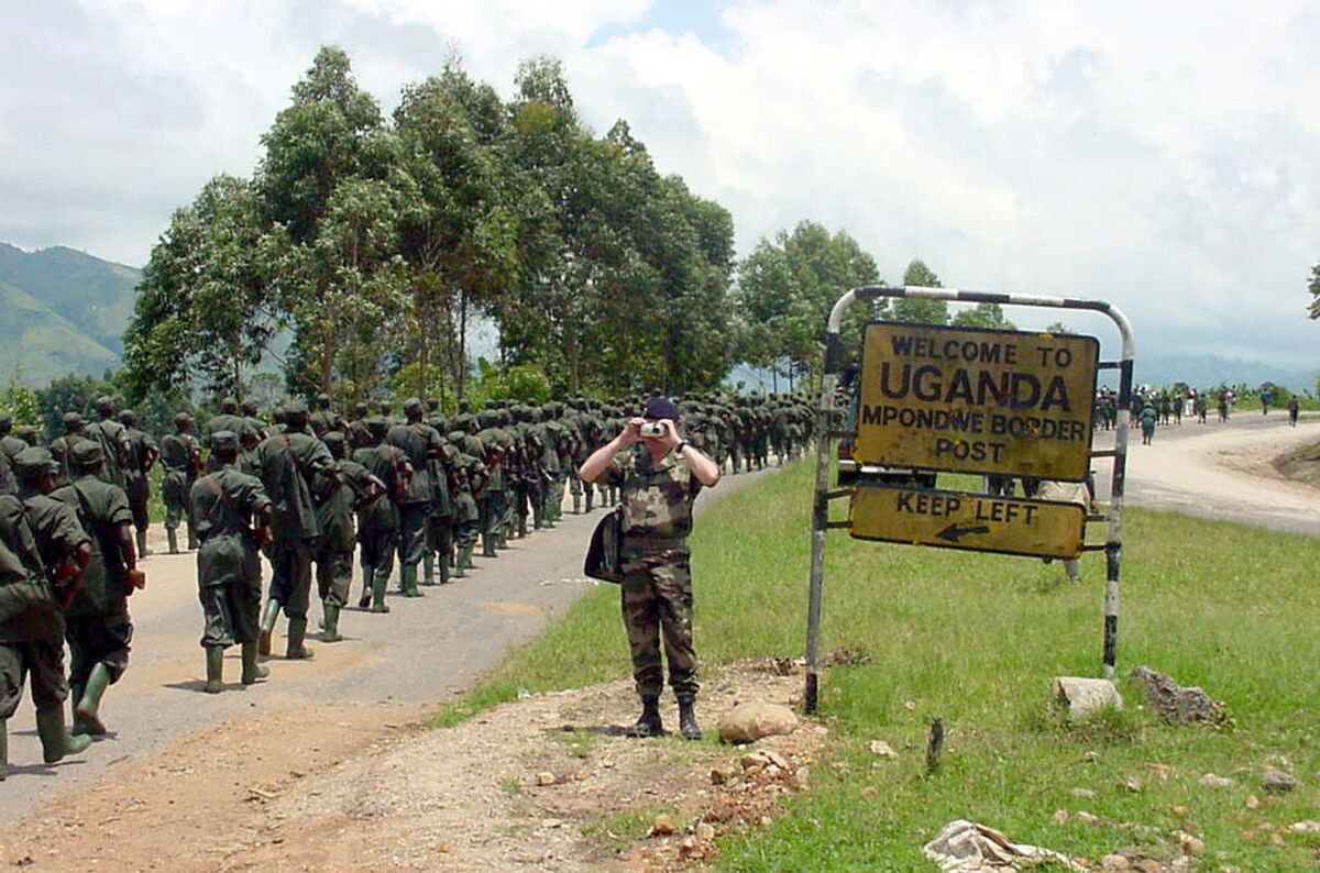 FILE - Ugandan soldiers who had been fighting Ugandan rebels in Congo for the previous three years, cross back into Uganda at the Mpondwe border point after walking some 700 kilometers (377 miles) since July from Bafwabwoli, Congo on Oct. 15, 2001. The International Court of Justice on Wednesday, Feb. 9, 2022 ordered Uganda to pay $325 million in compensation to its neighbor Congo for violence in a long-running conflict between the African neighbors that began in the late 1990s. (AP Photo/Chris Mamu, File)