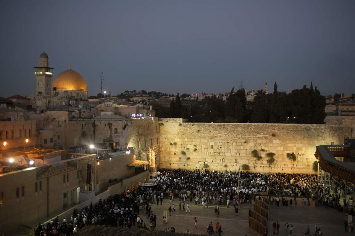 Jewish worshipers welcome the Sabbath by praying at the Western Wall in Jerusalem's Old City on Friday. At the upper left are the Al Aqsa mosque and Noble Sanctuary.
