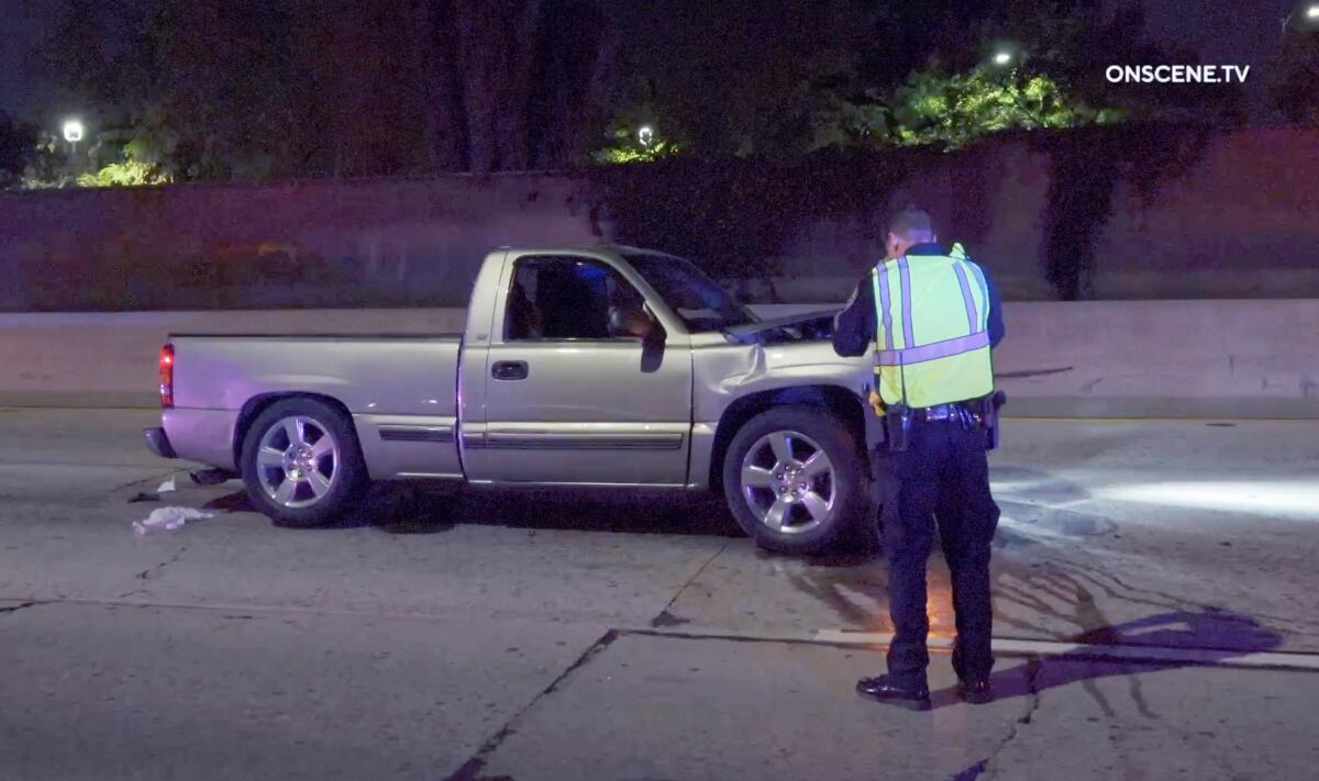 An investigator examines a pickup truck that was shot at early Wednesday.