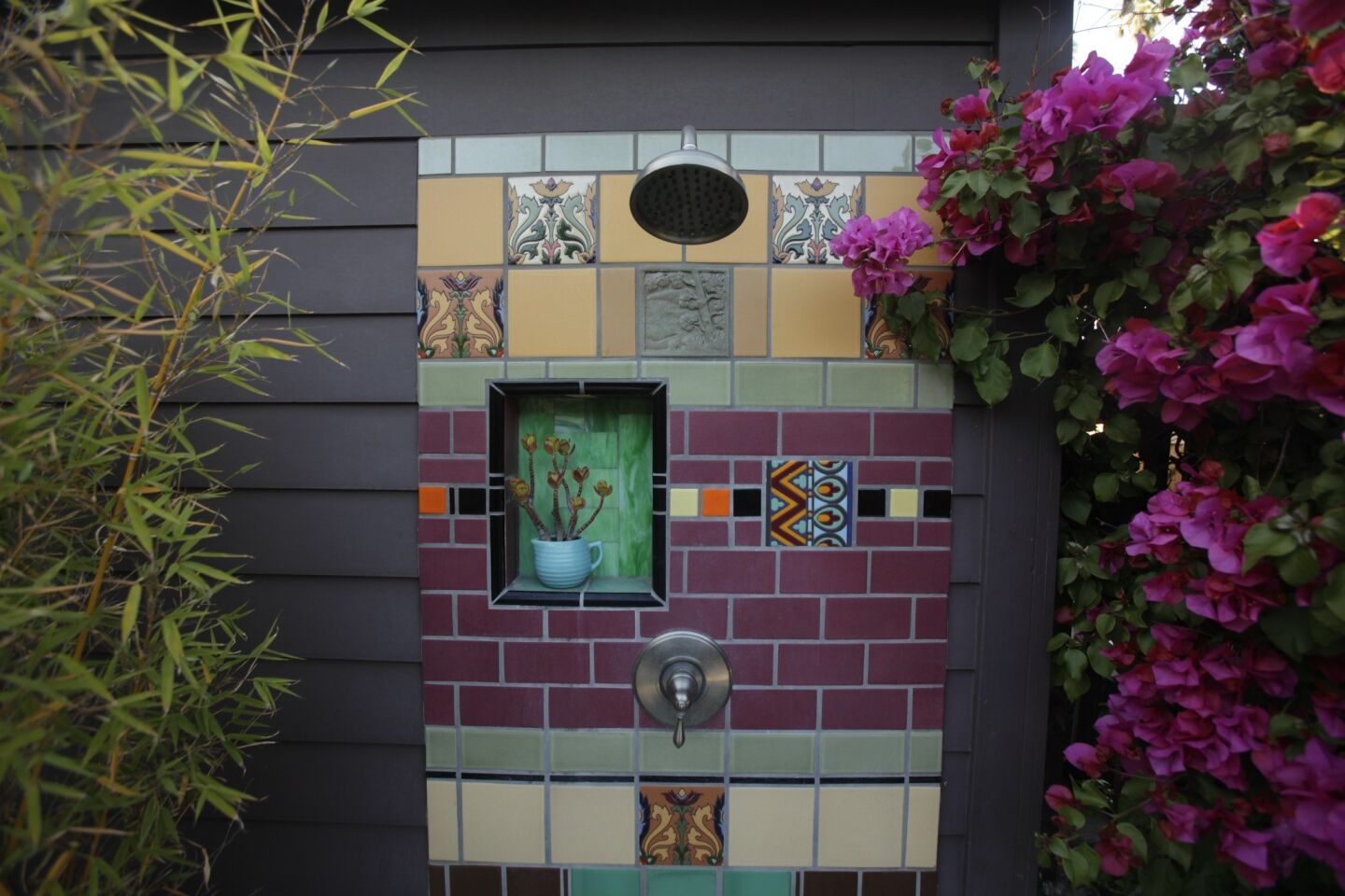 The outdoor shower is lined with a mix of classic Malibu tile, vintage ceramics and stained glass.