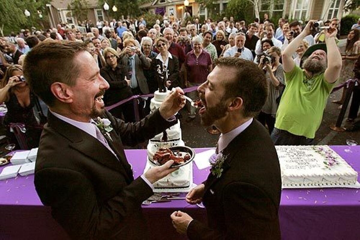Paul Waters, right, is served cake by Kevin Voecks in one of two cake cuttings after their wedding. Audio Slide Show >>>