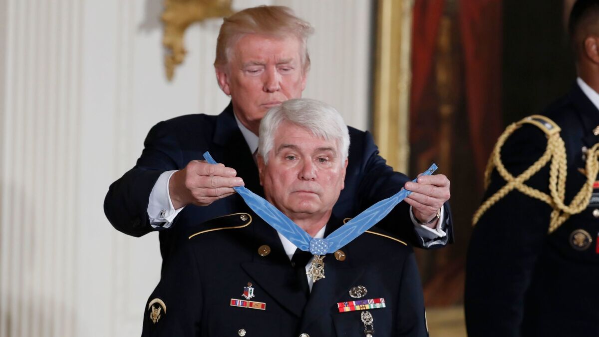 President Trump bestows the nation's highest military honor on retired Army medic James McCloughan at the White House on Monday.