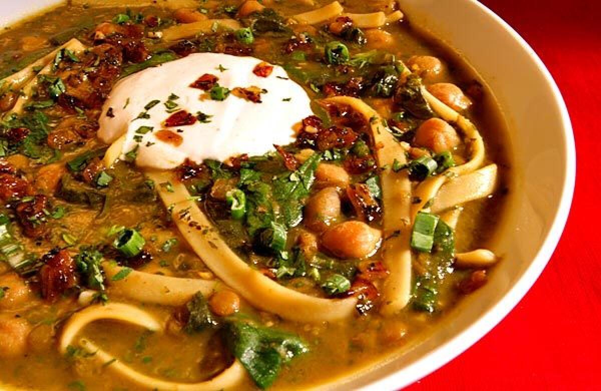 Chickpea and noodle soup with spinach, Persian herbs and kashk topping