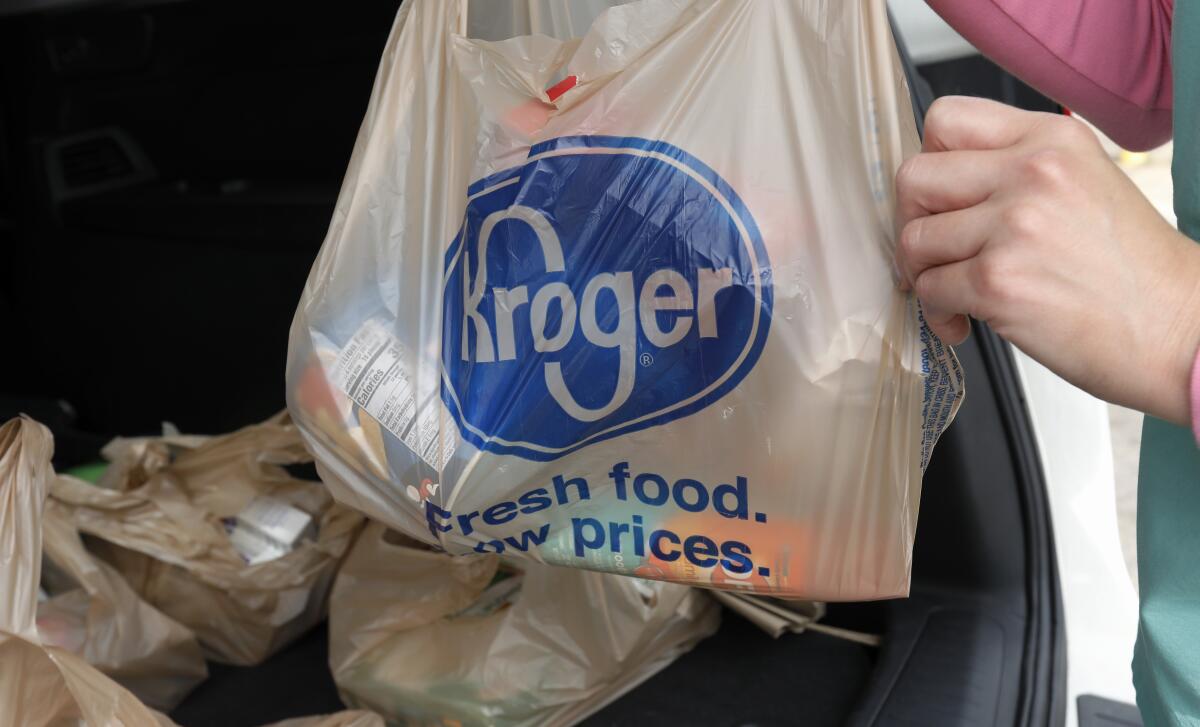 A customer removes her purchases at a Kroger grocery store