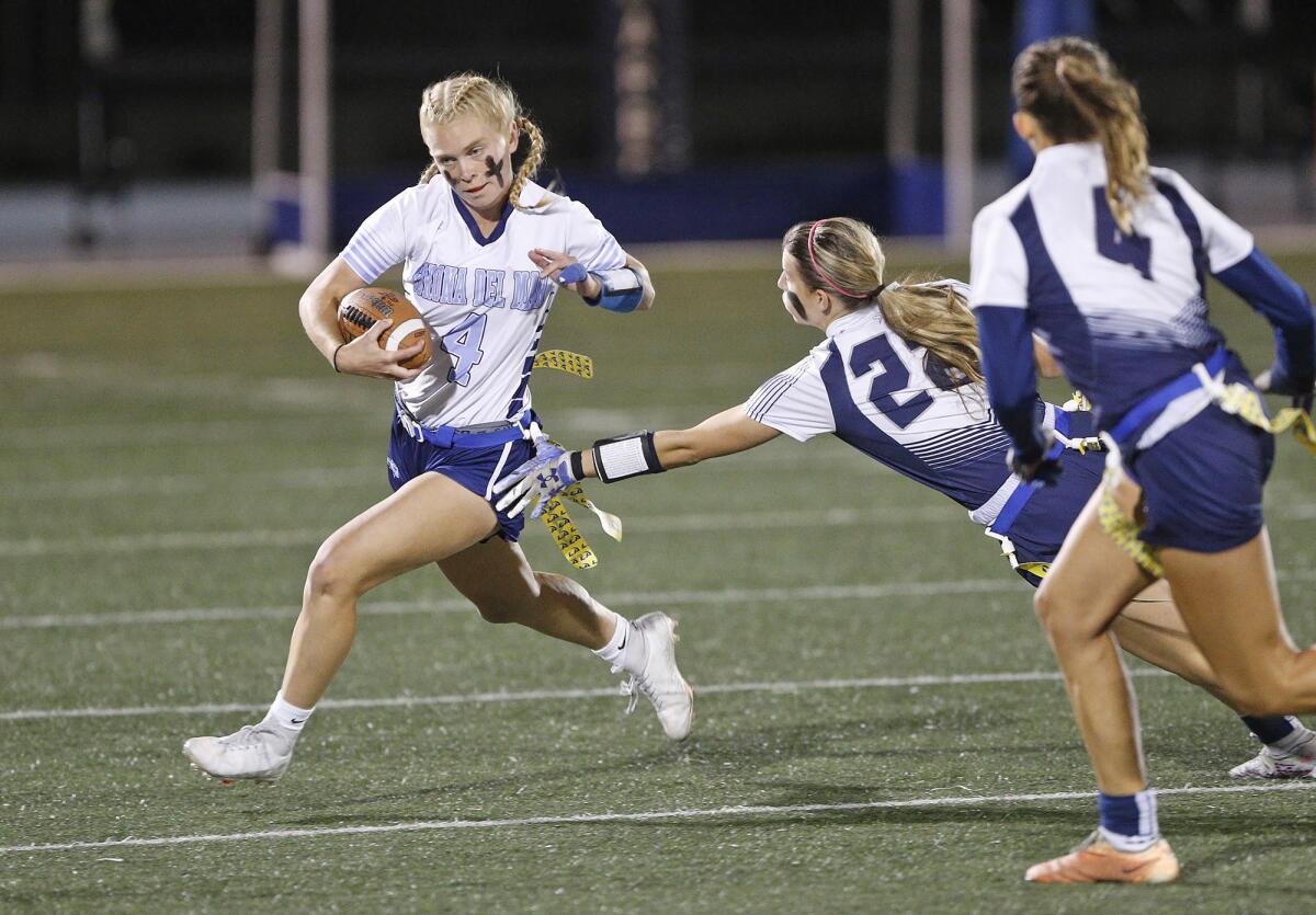 Corona del Mar quarterback Alexa Rokos is chased from the pocket by Audrey Burns (22) during Wednesday's game.