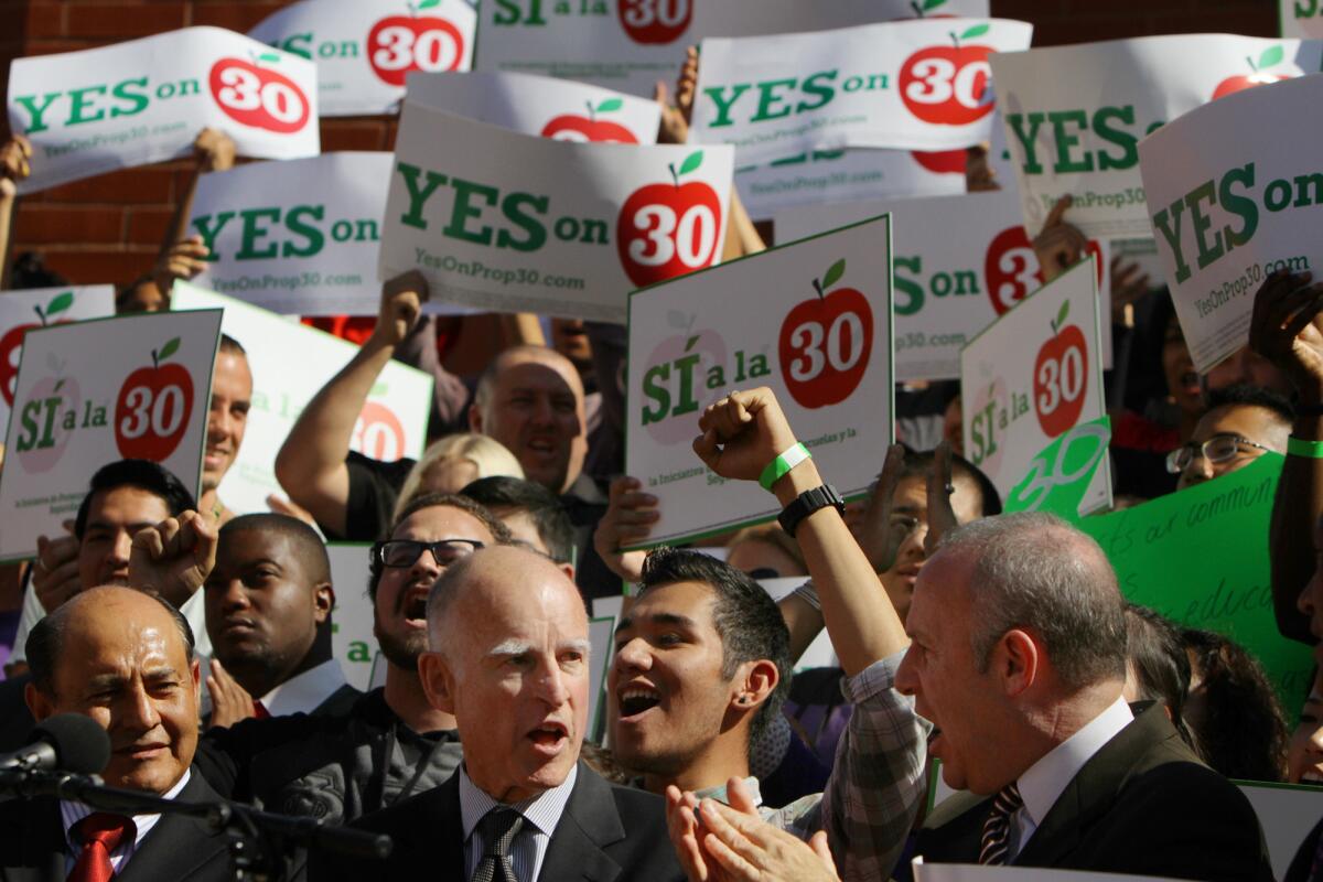 Sen. Lou Correa (D-Santa Ana), left, Gov. Jerry Brown and Sen. Darrell Steinberg (D-Sacramento) call for support of Proposition 30 during a rally in 2012.
