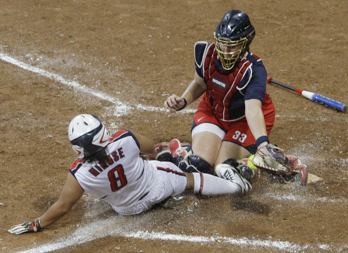 Japan's Megu Hirose scores against U.S. catcher Stacey Nuveman during the gold medal softball game at the 2008 Beijing Olympics in Beijing.