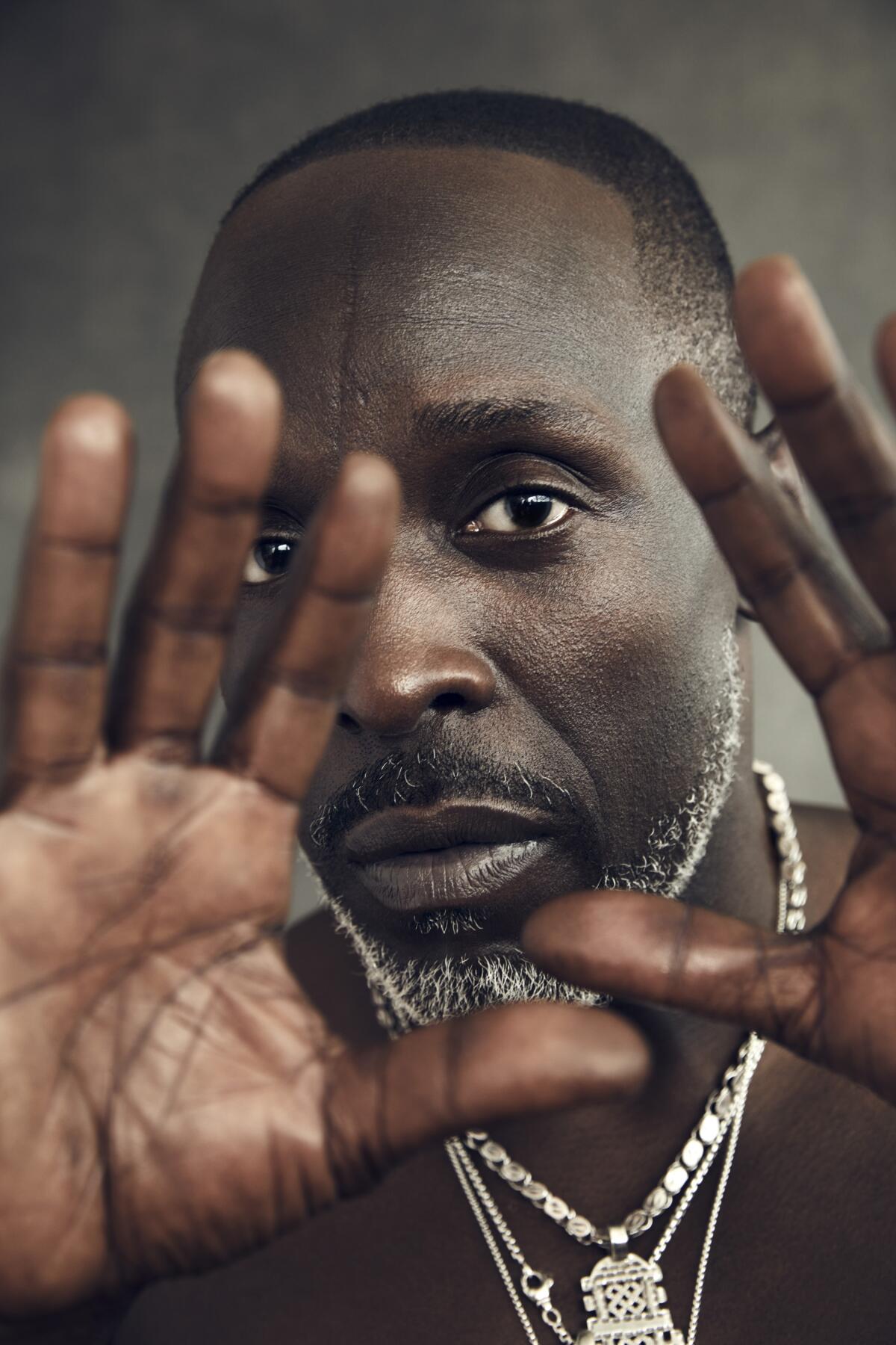 Michael K. Williams with his hands framing his face.