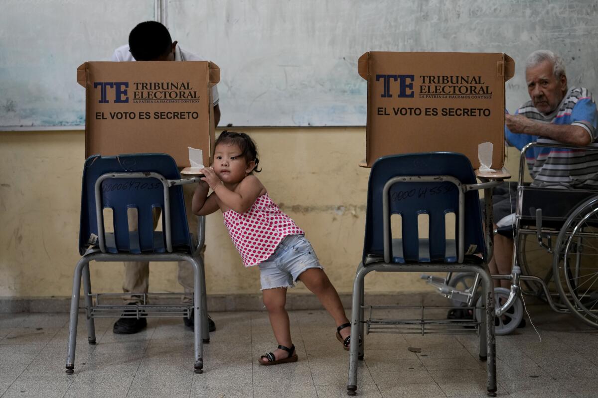 A girl waits for an adult to vote during a general election in Panama City.
