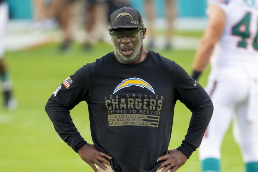 Los Angeles Chargers head coach Anthony Lynn wears a face shield and a Salute to Service shirt.