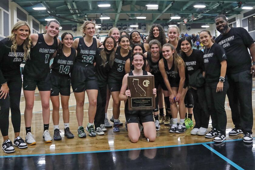 The Sage Hill girls' basketball team pose with the championship trophy after winning the girls' CIF State Southern California Regional Division II basketball final against Corona Santiago on the road, Tuesday.