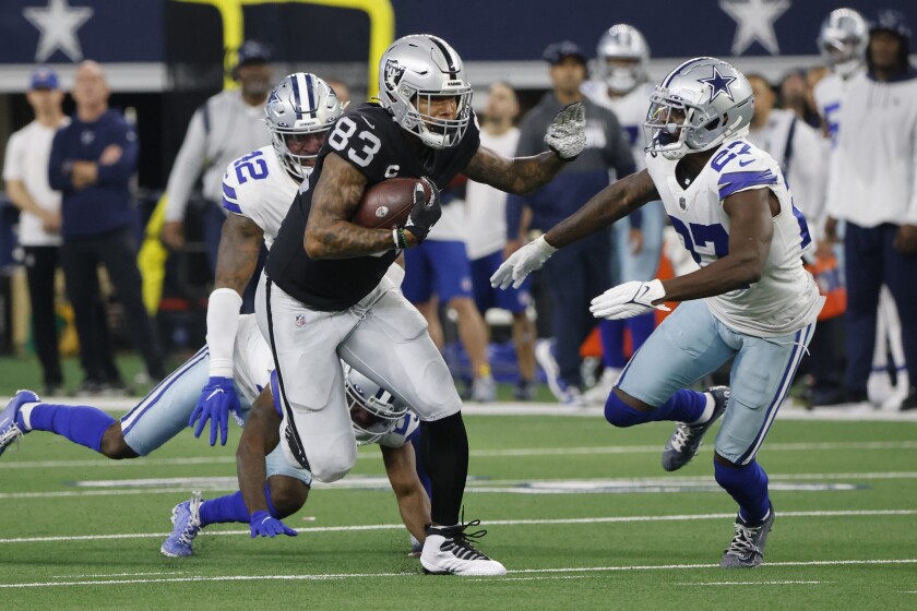 Las Vegas Raiders tight end Darren Waller (83) picks up a first down after catching a pass as Dallas Cowboys' Keanu Neal (42) and Jayron Kearse (27) move in to make the stop in the first half of an NFL football game in Arlington, Texas, Thursday, Nov. 25, 2021. (AP Photo/Michael Ainsworth)