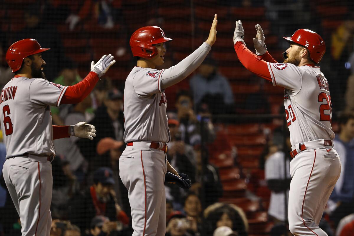 Angels' Jared Walsh is greeted at home plate by Anthony Rendon and Shohei Ohtani after his three-run home run.